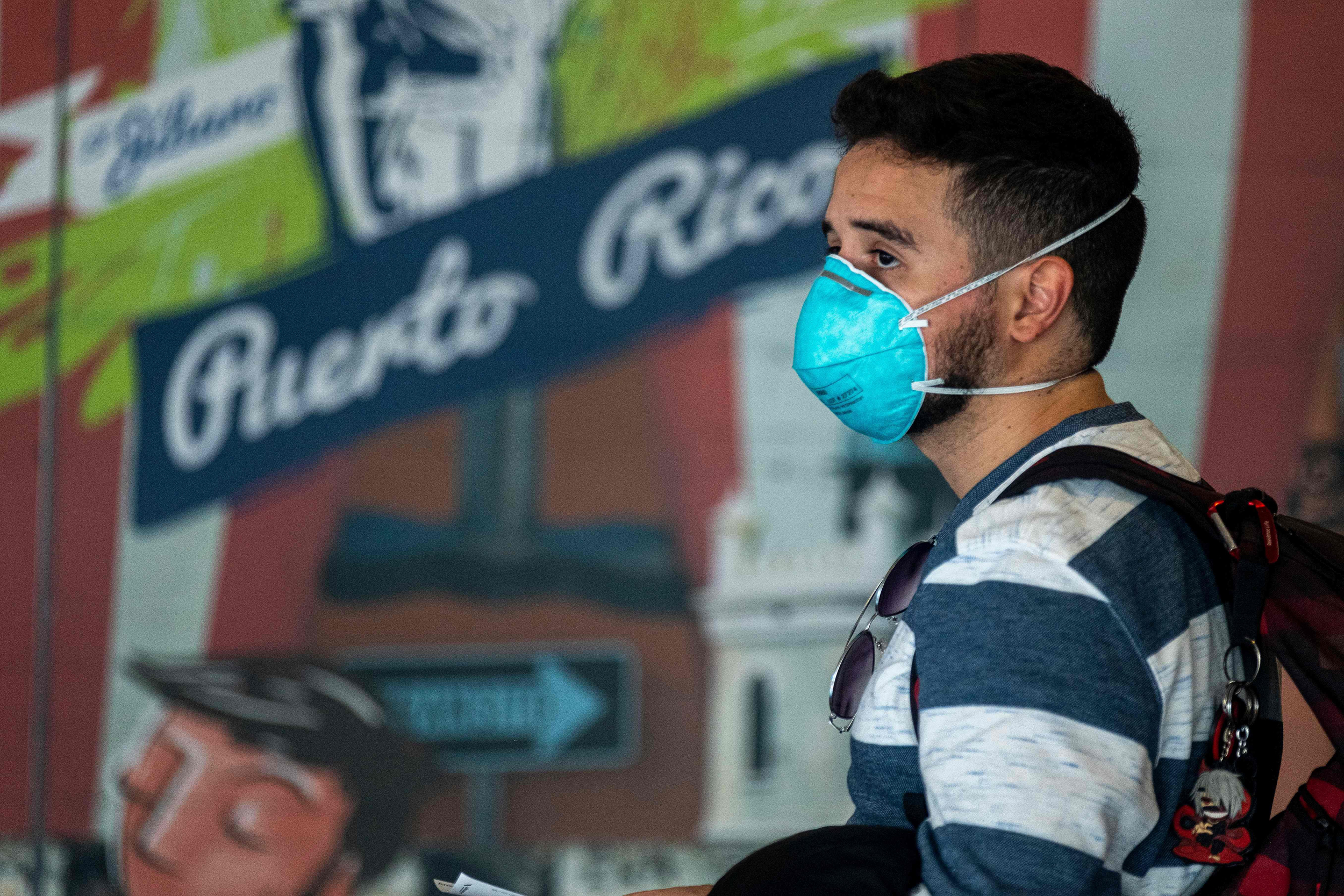 Viajere con mascara facial tras la pandemia del Coronavirus en el aeropuerto Luis Munos Marin en San Juan PR - ahora US